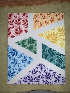 a piece of paper that has been cut into four different shapes and colors with leaves on it