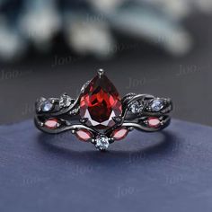 a red and white diamond ring sitting on top of a blue surface