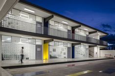 a person walking in front of a building with glass blocks on the outside and yellow doors