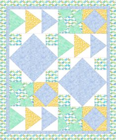 a blue and yellow quilt with triangles on the front, in different shades of green