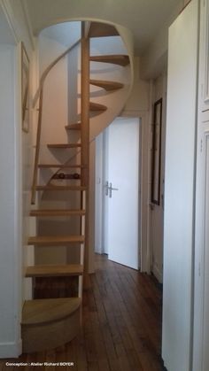 there is a spiral staircase in the hallway next to the door on the right side