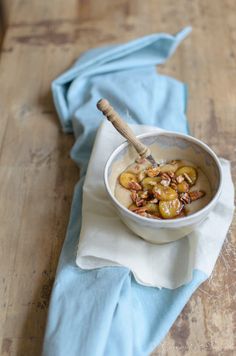 a bowl filled with food sitting on top of a wooden table next to a blue towel