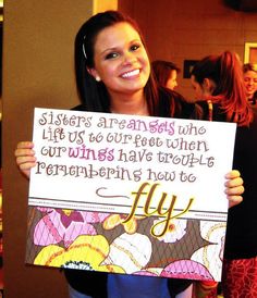 a woman holding up a sign that says, sisters are friends