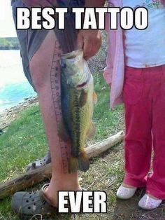 two people standing next to each other holding up a fish on a measuring tape with the caption best tattoo ever