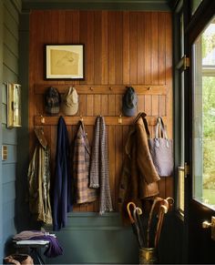 the coat rack is filled with hats and umbrellas