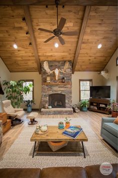 a living room with couches, tables and a fireplace in the middle of it