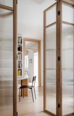 an open door leading to a dining room with chairs and a table in the background