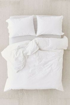 two pictures of a bed with white sheets and pillows