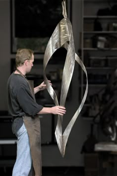 a man standing next to a metal sculpture