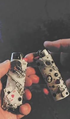 two hands holding some type of lighter in their palms, with the lighter being held by another hand