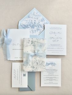 the wedding stationery is laid out on top of each other, with blue and white paper