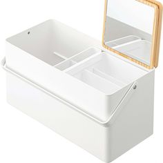 an empty white box with a mirror on the top and two compartments below it that are open