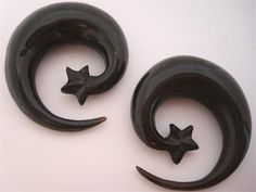 two black metal crescents with stars on the top and one in the middle, against a white background