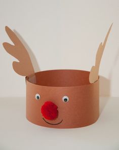 a paper cup with a reindeer's head and nose cut out on the side