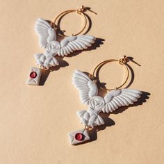 These flying white owls carry a letter below them and hang from gold circles! So iconic. Material: gold plated post backs, polymer clay Owl Clay Earrings, Polymer Jewellery, White Owls, Egyptian Goddess Art, 3d Earrings, Owl Post, Clay Moulding, Special Nails, Diy Earrings Polymer Clay