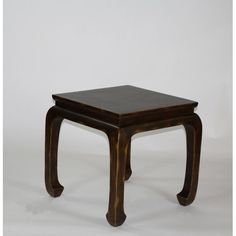 a small wooden table sitting on top of a white floor