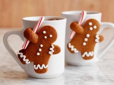 two mugs decorated with gingerbread cookies and candy canes