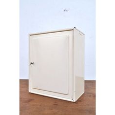 a white cabinet sitting on top of a wooden floor