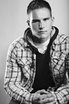 black and white photograph of a young man with his hands folded in front of him