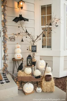 a porch decorated for halloween with pumpkins, hay bales and decorations on it