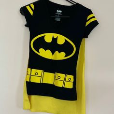 New Without Tags Never Worn, Batman T-Shirt With Velcro Attachable Cape. You Can Wear This Top With Or Without The Cape. V-Neck And Short Sleeve Black Tee With Yellow Screen Printed Batman Logo And Belt. Please Consider Bundling This Tshirt With Other Items From My Closet To Save On Shipping And 20%! Anything Paired With This Shirt Will Ship For Free! Please Take A Look Around In My Closet, Because I Love Giving Huge Discounts For Big Bundles! Also, Follow Me So That You Can Get New Unlisted Inv Yellow V-neck Graphic Print T-shirt, Batman Yellow, Yellow Screen, Batman Costume, Batman T Shirt, Batman Logo, T Shirt Costumes, Yellow Black, Black N Yellow