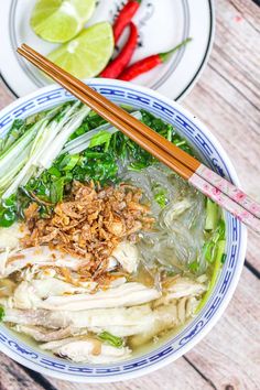 two bowls filled with food and chopsticks sitting on top of a wooden table