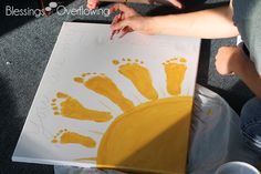 someone is making a hand and footprint art project for their child's feet