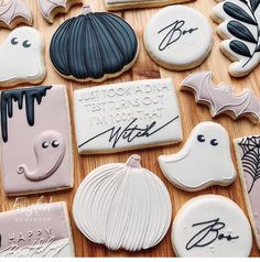 many decorated cookies on a wooden table with writing and decorations in black, white, and pink