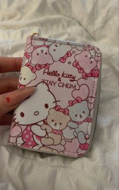 a hello kitty coin purse is shown on a bed