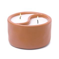 two candles in a clay container on a white background