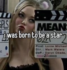 a woman holding up a sign that says i was born to be a star