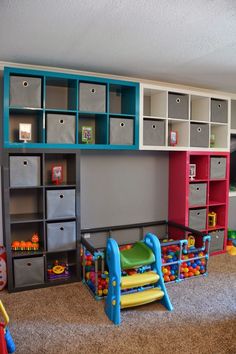 there are many toys in this playroom with colorful shelves and bins on the wall