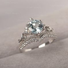 a ring with an aqua blue topazte surrounded by diamonds