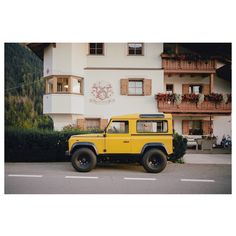 a yellow jeep parked in front of a building