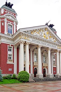 a red and white building with statues on top