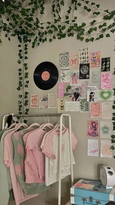 a room with plants growing on the wall and clothes hanging up in front of it