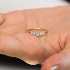 a woman's hand holding a three stone ring