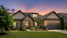 a large house is shown at dusk with the sun going down in the sky behind it