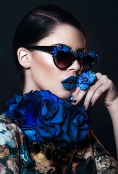 a woman with sunglasses and blue flowers on her face