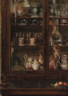 an old china cabinet filled with dishes and cups