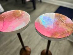 two round tables with pink and blue paint on them in a living room or dining room