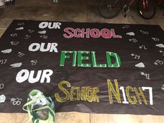 a black banner with writing on it that says our school is our field our senior night