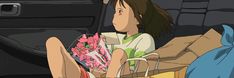 a woman sitting in the back seat of a car holding flowers