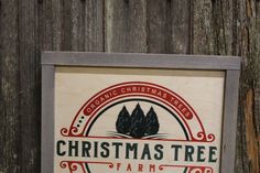 a christmas tree farm sign on the side of a wooden fence