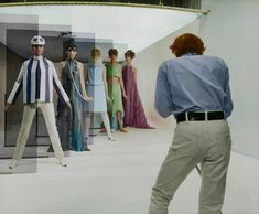 a man standing in front of a group of mannequins