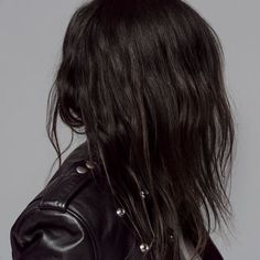 a woman with long hair wearing a black leather jacket