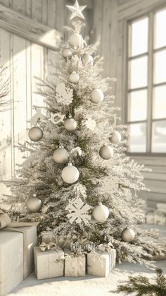 a white christmas tree with presents under it