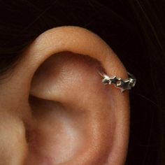 an ear with two small stars on it's side and one smaller star in the middle