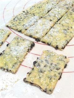 several squares of food sitting on top of a cooling rack covered in powdered sugar