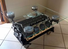 an engine block coffee table on wheels with glass top